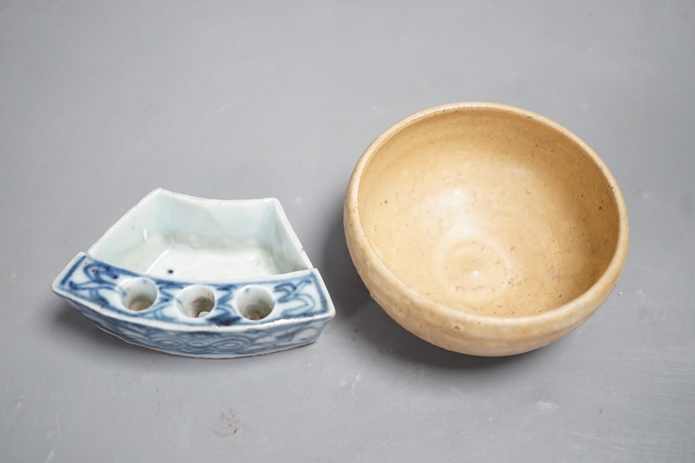 A Chinese late Qing blue and white penholder, 8cm and a South East Asian buff glazed cup
